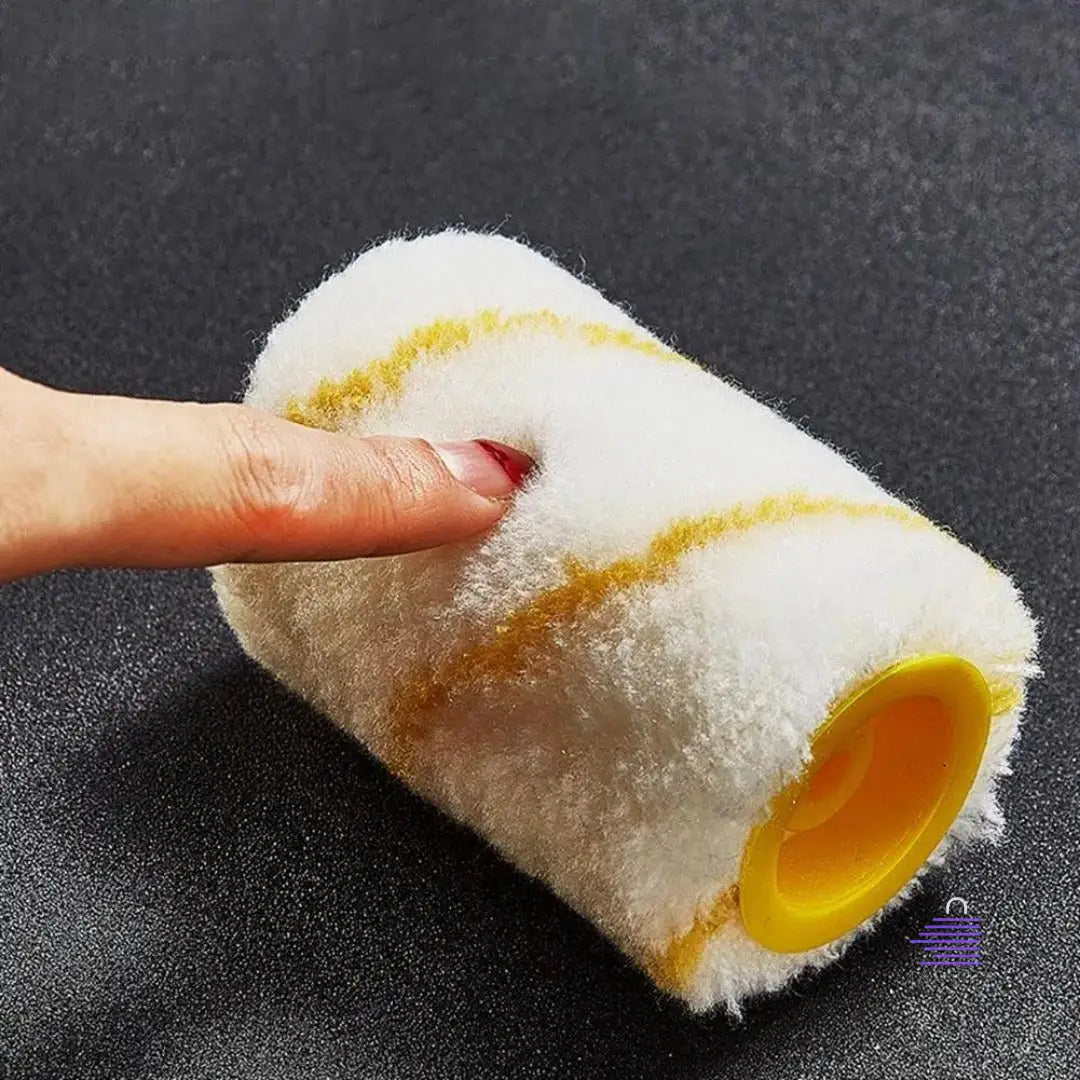 A person is holding a yellow and white EdgeMaster Paint Roller by Martify on a black surface.